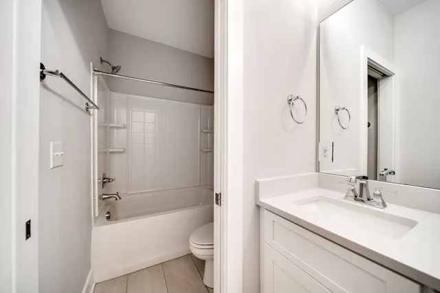 a bathroom with a bathtub shower sink vanity and toilet