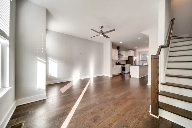 a view of a living room with wooden floor and windows