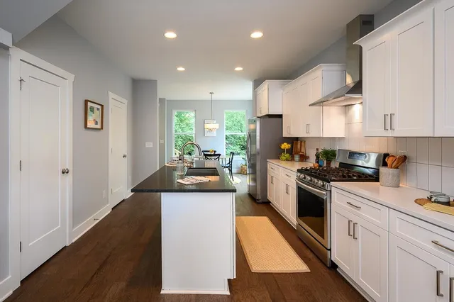 a bathroom with a granite countertop sink a toilet a mirror and shower