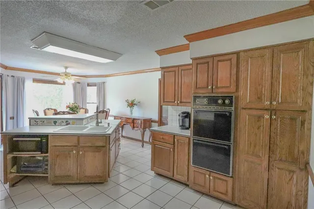 a dining hall with stainless steel appliances granite countertop a refrigerator and a sink