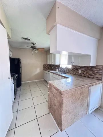 a kitchen with granite countertop a stove and a refrigerator