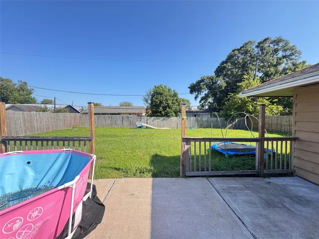 a view of backyard with swimming pool and seating space