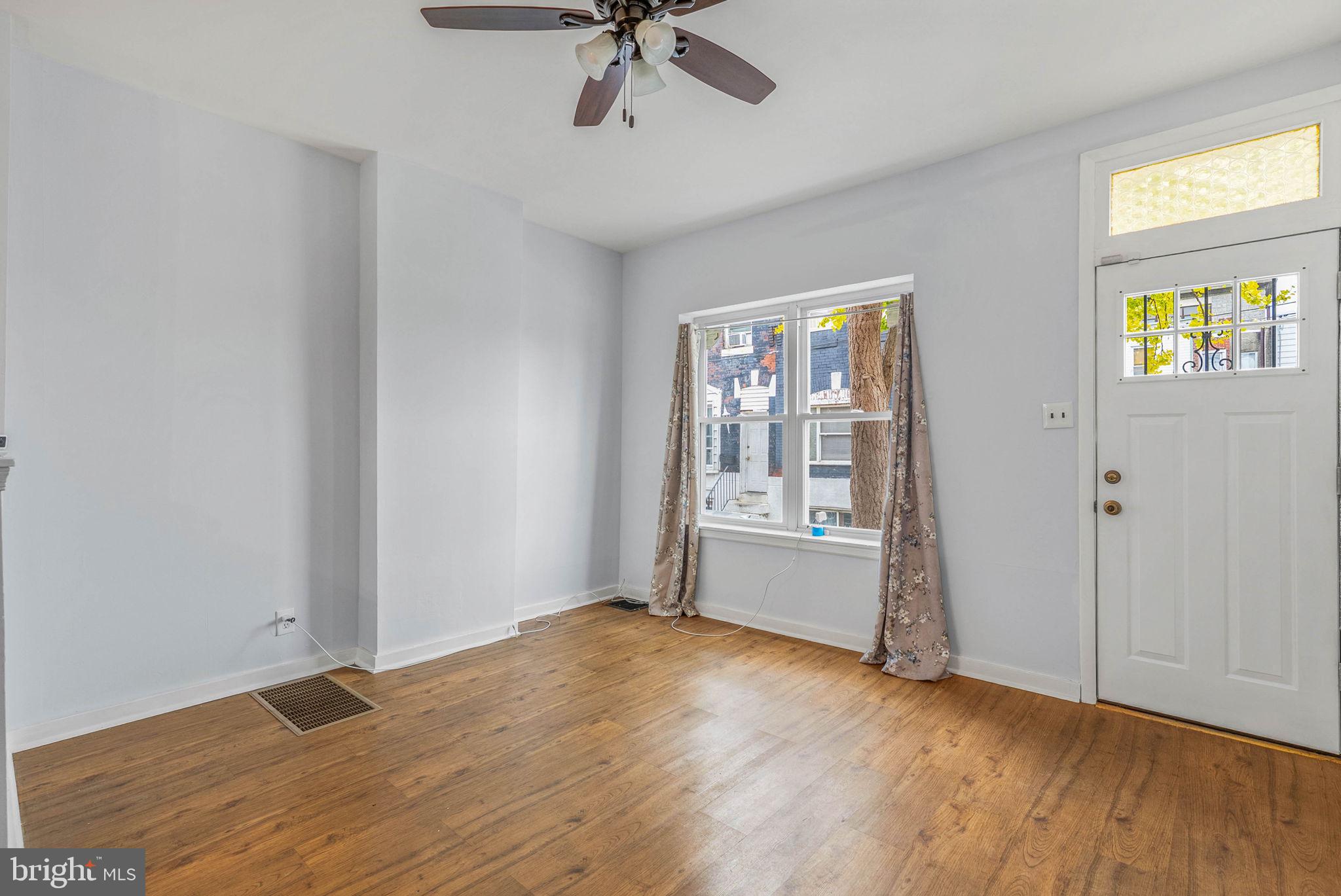 2951 Gerritt Street Philadelphia, PA 19146 - Photo 5 of 21 an empty room with wooden floor chandelier fan and windows