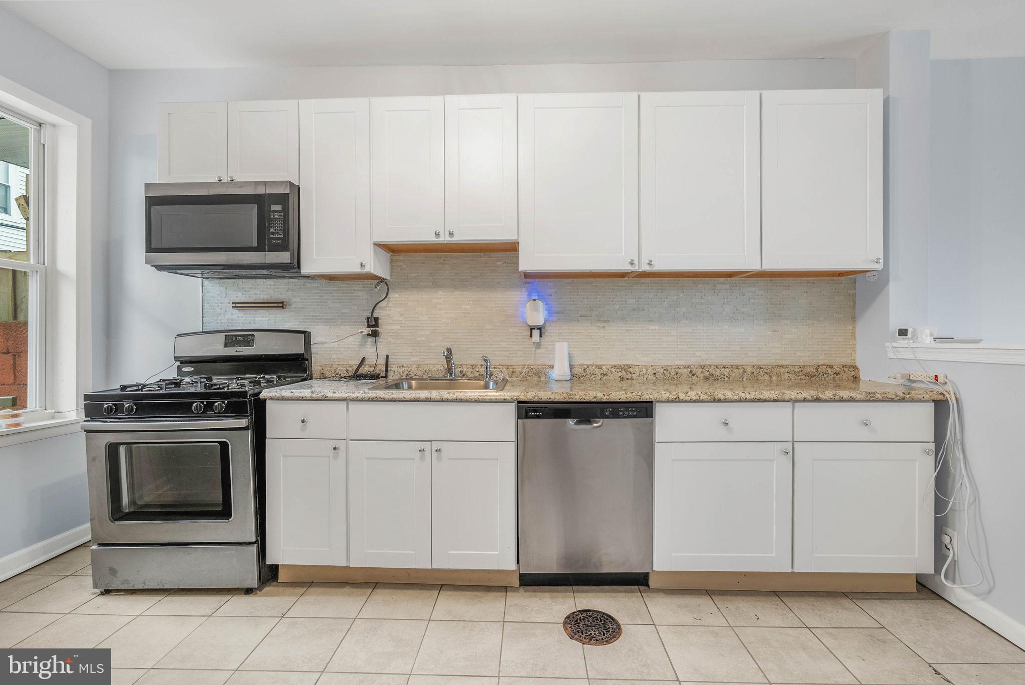 2951 Gerritt Street Philadelphia, PA 19146 - Photo 9 of 21 a kitchen with granite countertop white cabinets stainless steel appliances and a sink