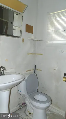a white toilet sitting next to a bathroom sink and tub