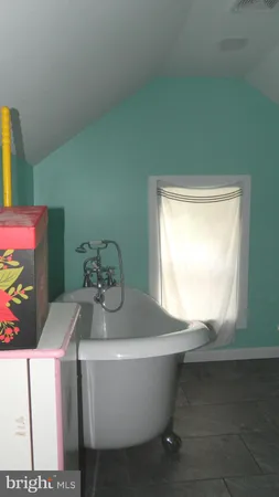 a white bath tub sitting in a bathroom next to a window