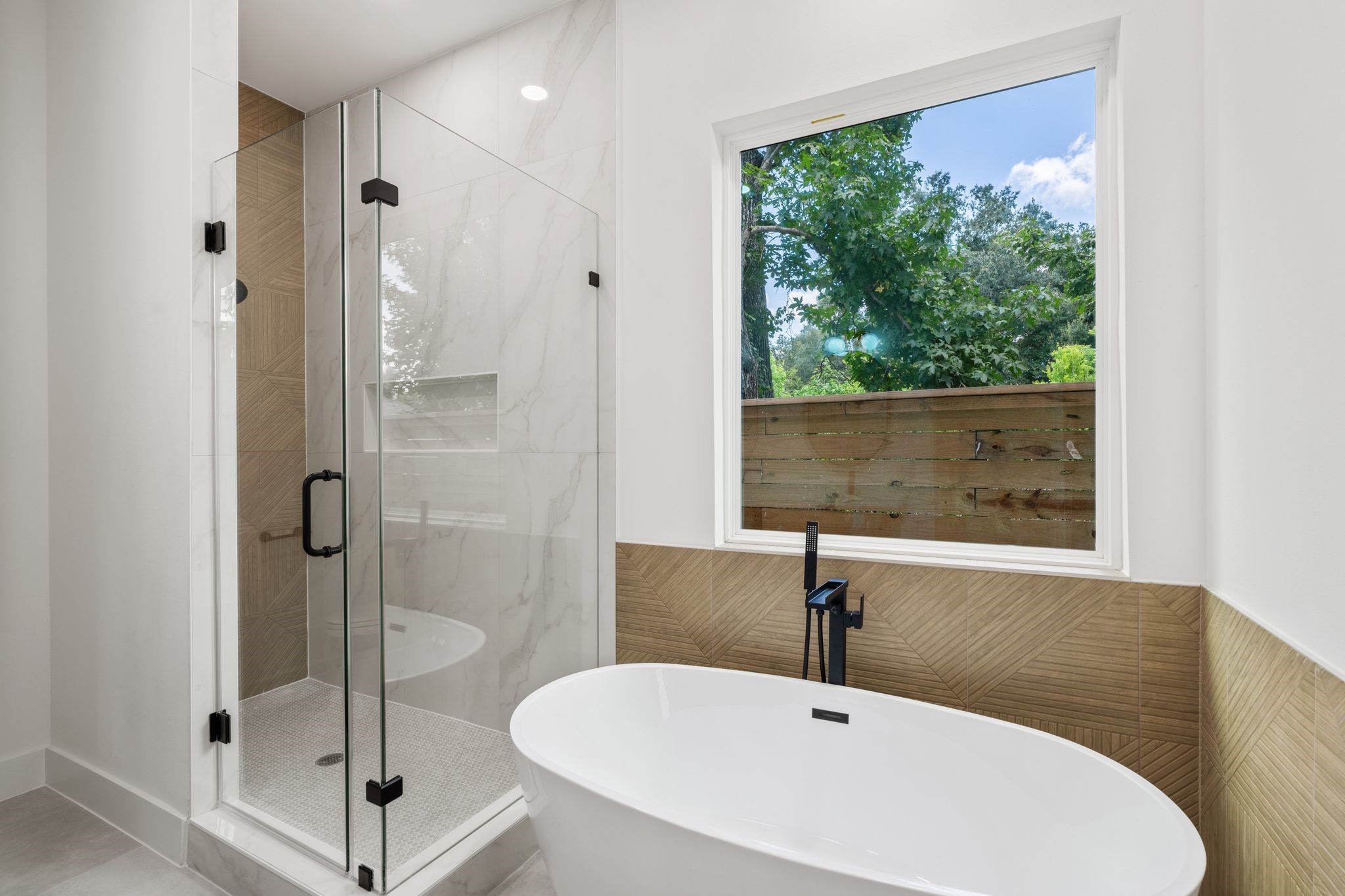 7321 Laura Koppe Road Houston, TX 77028 - Photo 37 of 41 Elegant bathroom featuring a spacious glass enclosed
shower, modern dual sinks, and
a luxurious free standing bathtub with a serene view.
