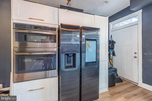 a kitchen with granite countertop stainless steel appliances and wooden floor