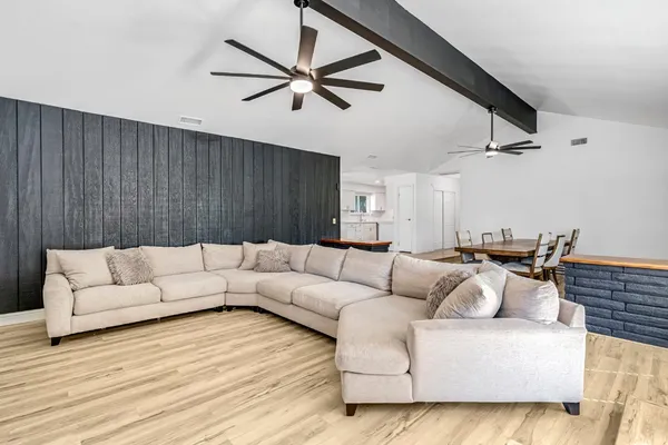 a living room with furniture and a ceiling fan