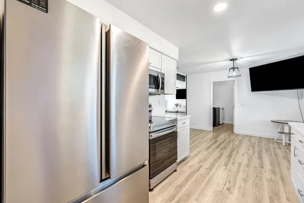 a open kitchen with white cabinets and stainless steel appliances