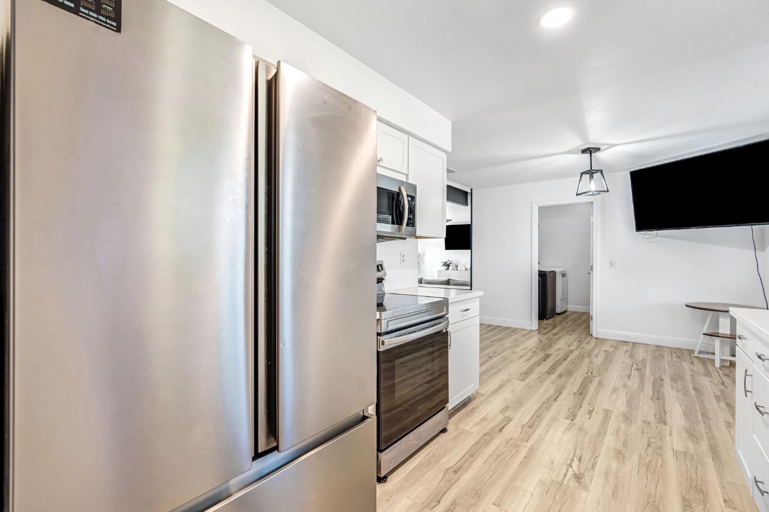2428 West 3rd Street Madera, CA 93637 - Photo 21 of 39 a open kitchen with white cabinets and stainless steel appliances