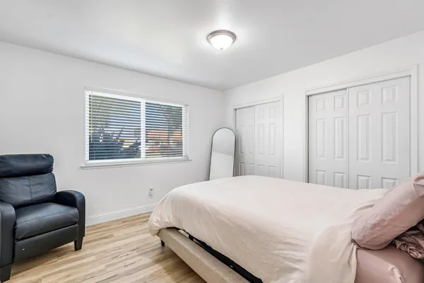a bedroom with a bed and wooden floor