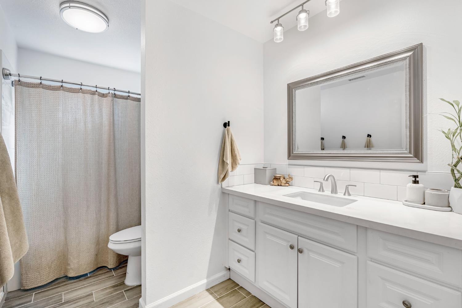 2428 West 3rd Street Madera, CA 93637 - Photo 24 of 39 a bathroom with a double vanity sink toilet mirror and shower