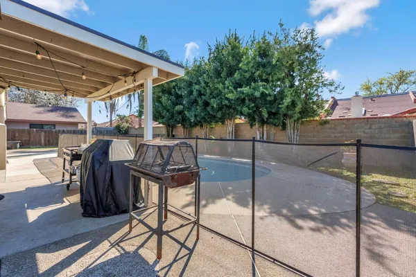 a view of two chairs and table in the patio