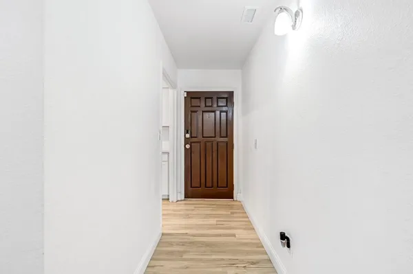 a view of a hallway with wooden floor