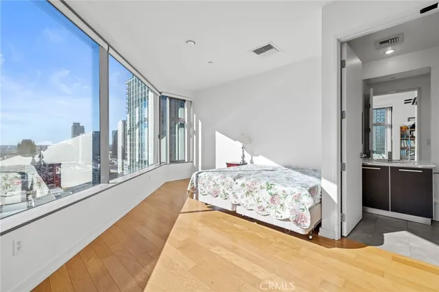 a bedroom with a large bed and a large mirror on dresser