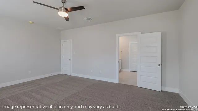 an empty room with closet and a ceiling fan