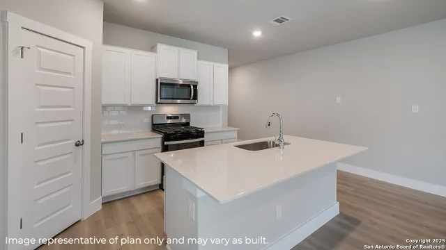 a kitchen with a sink cabinets and stainless steel appliances
