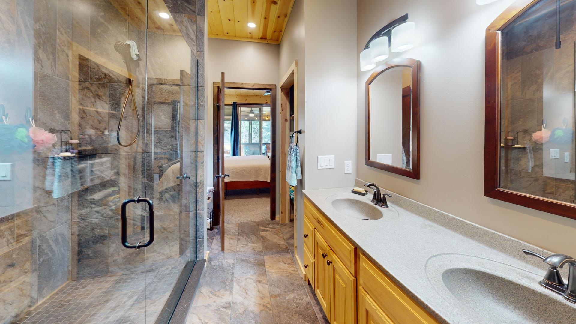 7523 Nelson Road Crane Lake, MN 55725 - Photo 21 of 50 Ensuite bathroom featuring double vanity, a sink, connected bathroom, and a shower stall