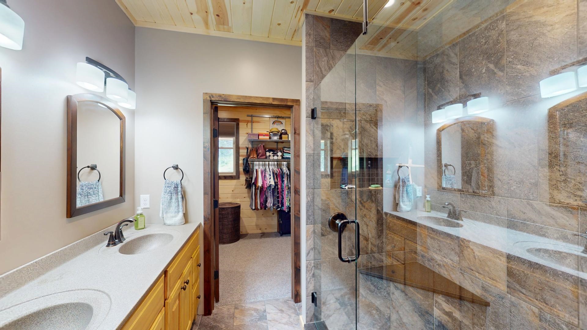 7523 Nelson Road Crane Lake, MN 55725 - Photo 22 of 50 Bathroom featuring a shower stall, double vanity, and a sink