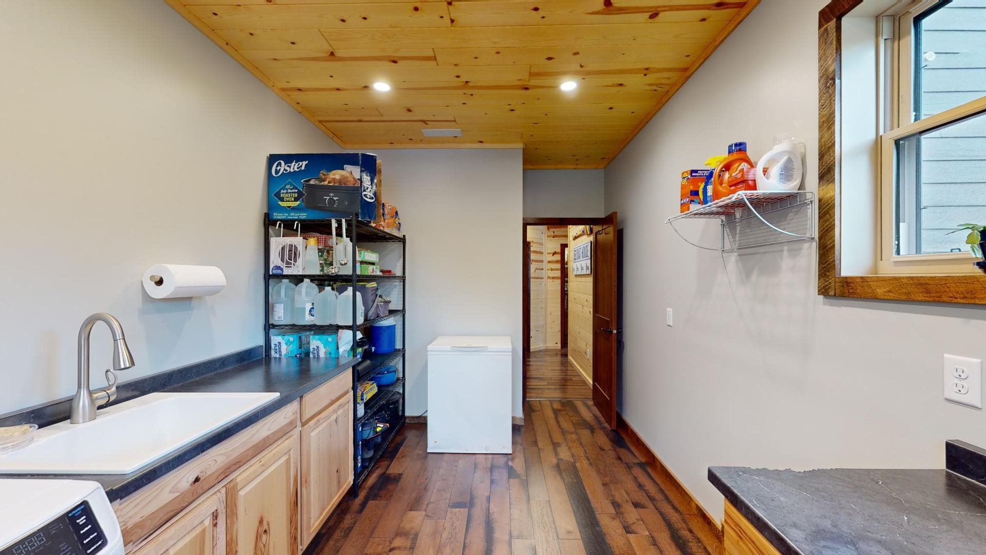 7523 Nelson Road Crane Lake, MN 55725 - Photo 25 of 50 Kitchen featuring wooden ceiling, a sink, dark wood-style floors, washer / dryer, and dark countertops