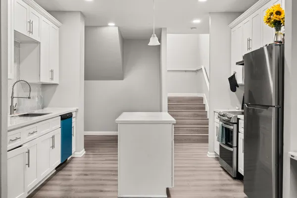 a kitchen with a refrigerator sink and wooden cabinets