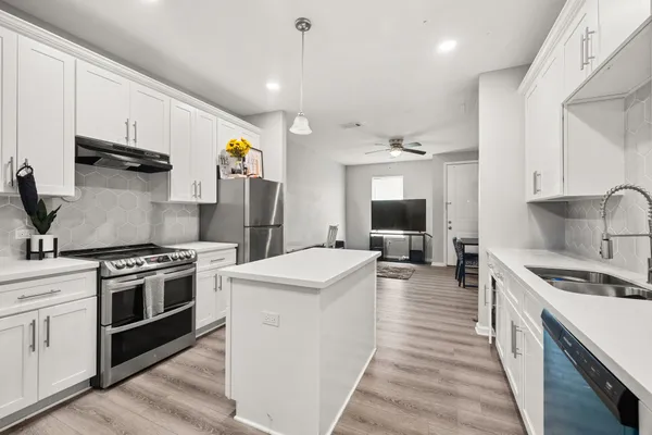 a kitchen with stainless steel appliances granite countertop a stove and a sink