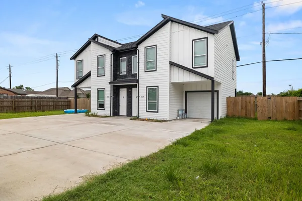 a view of an house with backyard and road