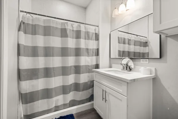 a bathroom with a sink a toilet a mirror and shower curtain