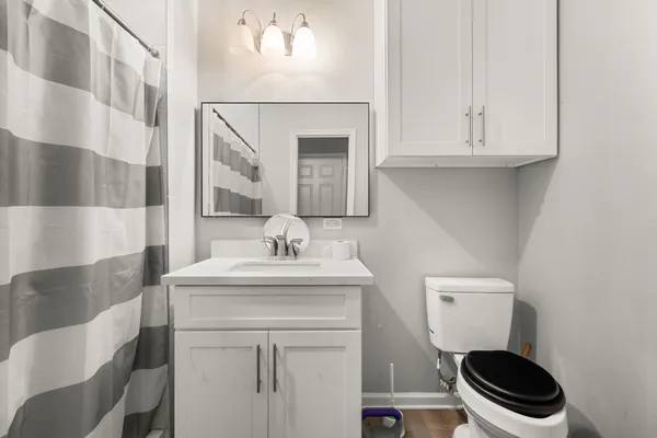 a bathroom with a toilet a sink and a mirror