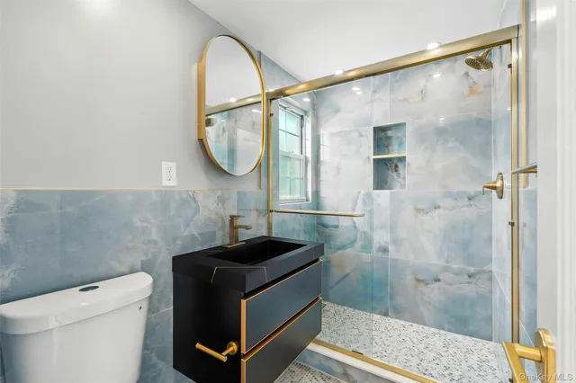 a bathroom with a shower a toilet and a sink