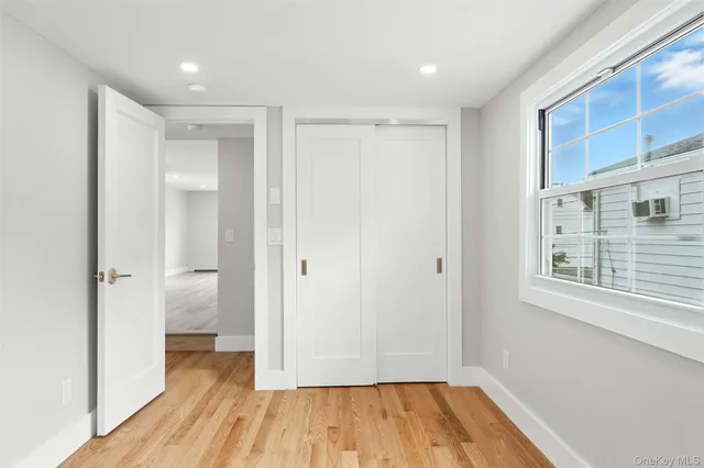 a view of a hallway with wooden floor and a window