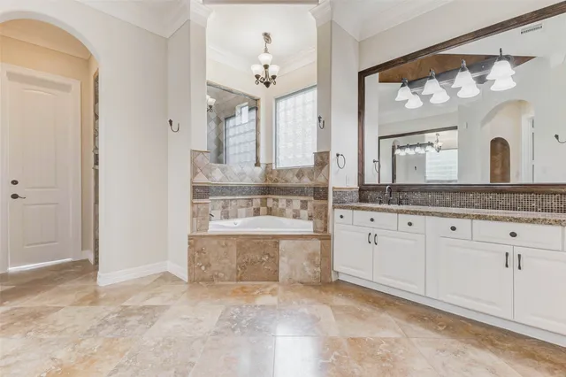 a bathroom with a tub a sink and mirror