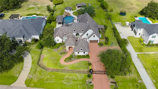 a aerial view of a house with swimming pool and large trees