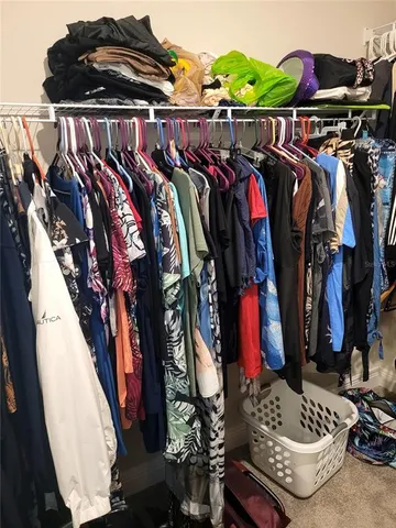 a view of walk in closet with clothes and shoes