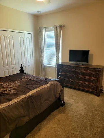 a bed sitting in a bedroom next to a cabinet