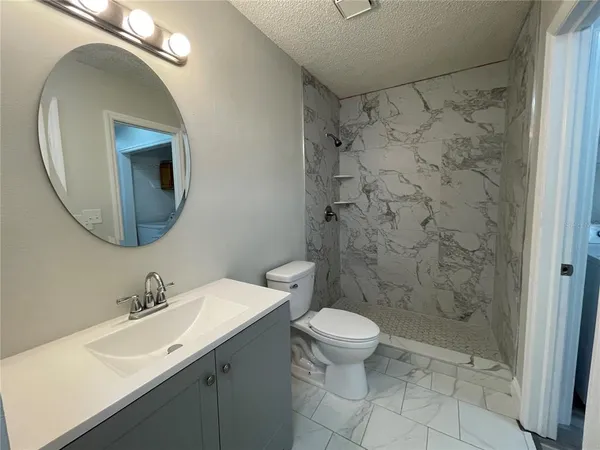 a bathroom with a sink a toilet and shower