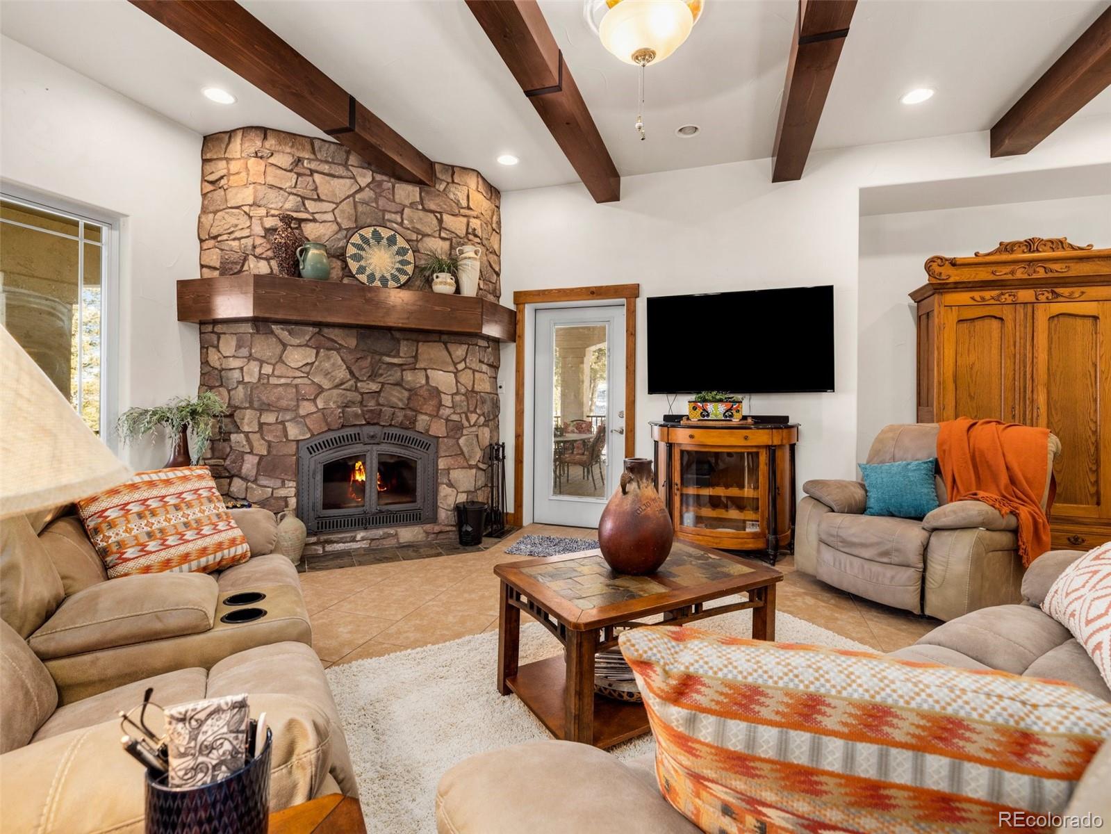 8760 Ridge Road Beulah, CO 81023 - Photo 13 of 33 a living room with furniture a flat screen tv and a fireplace