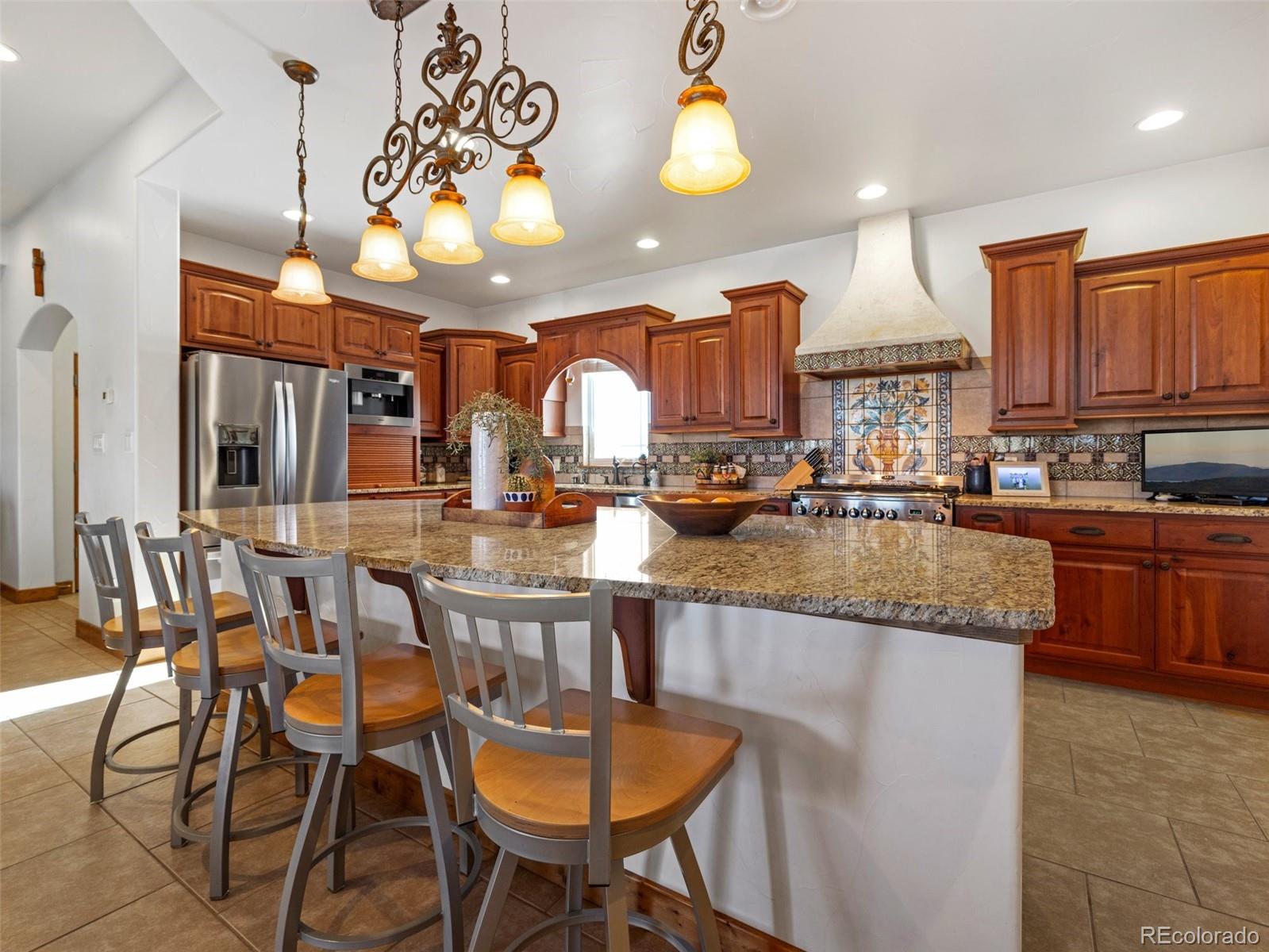 8760 Ridge Road Beulah, CO 81023 - Photo 16 of 33 a kitchen with stainless steel appliances granite countertop a stove top oven a sink a dining table and chairs with wooden floor