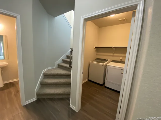 a view of a hallway with wooden floor and staircase