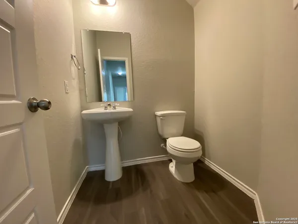 a bathroom with a toilet a sink and mirror