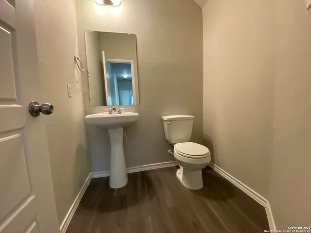 a bathroom with a toilet a sink and mirror