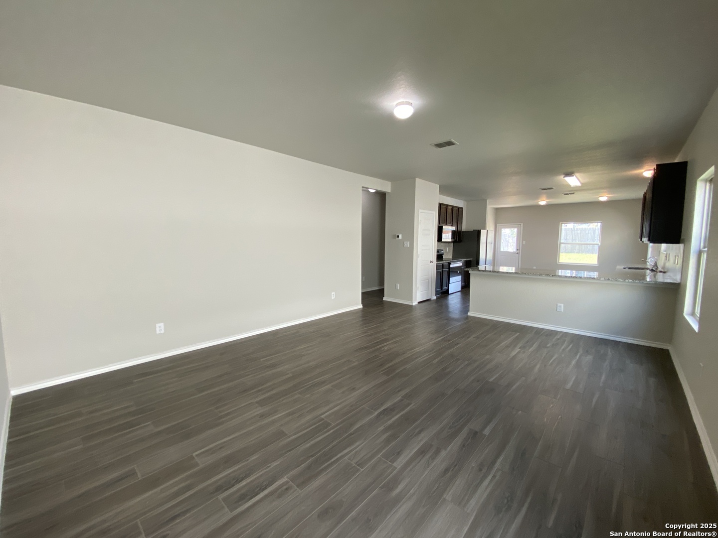 10822 Randolph Way Converse, TX 78109 - Photo 3 of 33 a view of a big room with wooden floor and a kitchen
