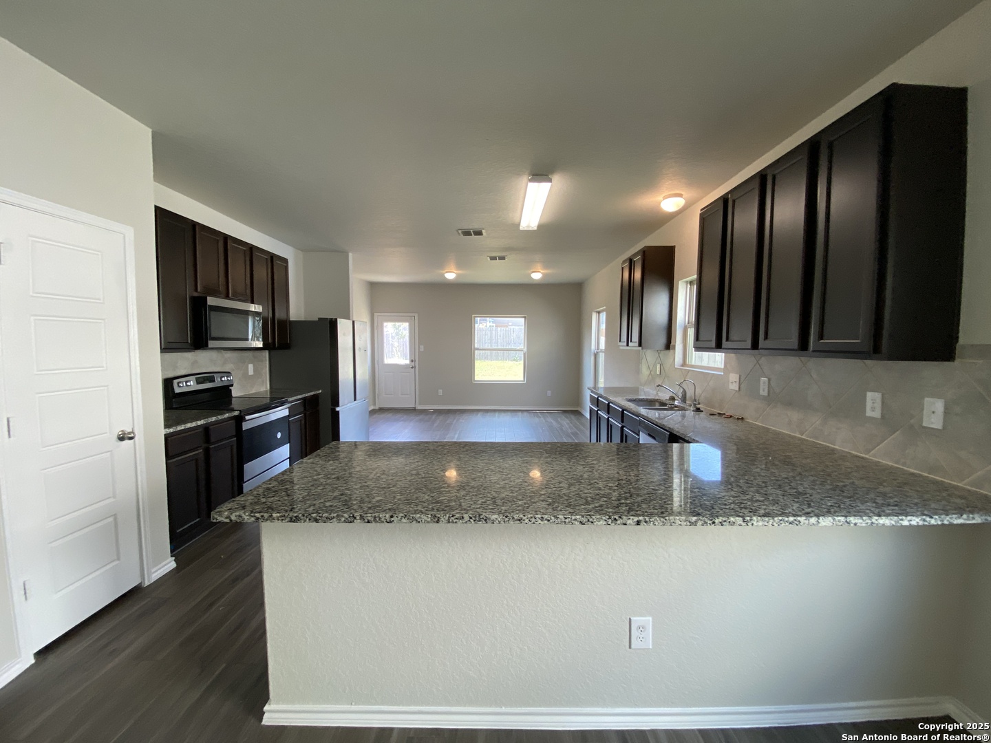 10822 Randolph Way Converse, TX 78109 - Photo 4 of 33 a kitchen with stainless steel appliances granite countertop a refrigerator a stove a sink a microwave and island