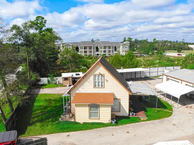 an aerial view of a house with a yard and a large tree