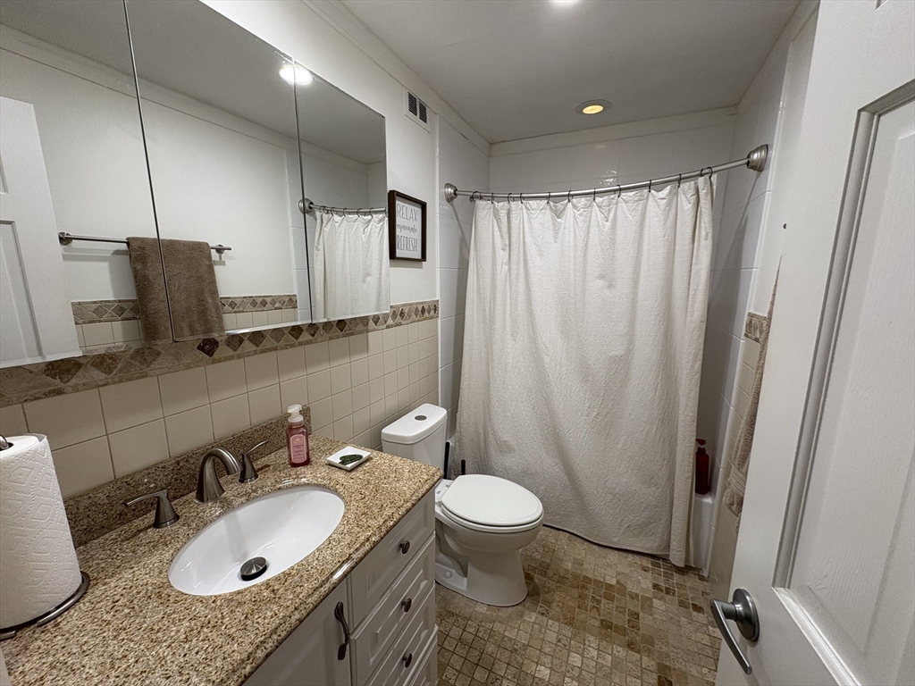 8 Shadowbrook Lane, Unit 14 Milford, MA 01757 - Photo 14 of 19 a bathroom with a granite countertop sink a mirror and a toilet