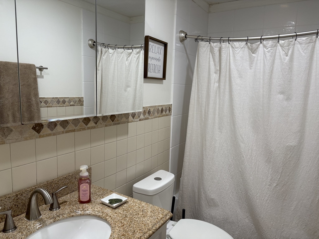 8 Shadowbrook Lane, Unit 14 Milford, MA 01757 - Photo 15 of 19 a bathroom with a sink a toilet and shower curtain