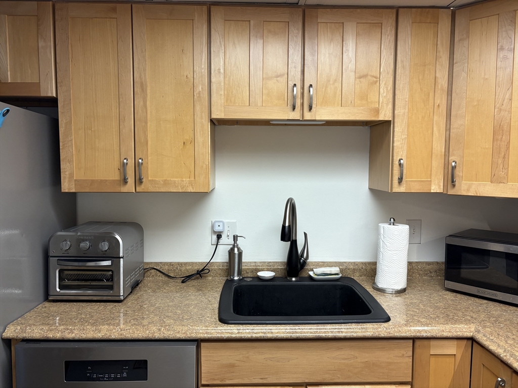 8 Shadowbrook Lane, Unit 14 Milford, MA 01757 - Photo 7 of 19 a kitchen with granite countertop a sink a stove and cabinets