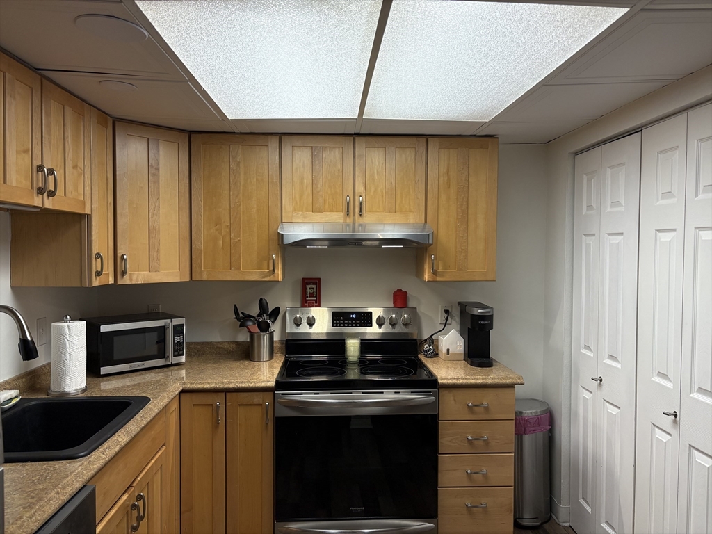 8 Shadowbrook Lane, Unit 14 Milford, MA 01757 - Photo 9 of 19 a kitchen with a stove a sink and cabinets