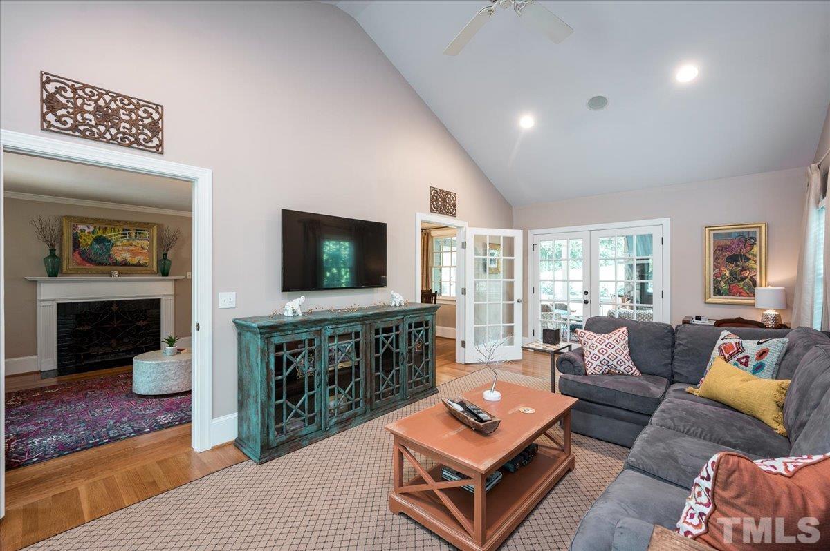 2901 Hostetler Street Raleigh, NC 27609 - Photo 8 of 25 a living room with furniture a flat screen tv and a chandelier